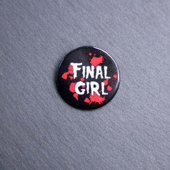 Final Girl Red Button. These buttons are made with photo paper, metal round, and metal backing. These buttons are vibrant and fun to use on bags or vests.