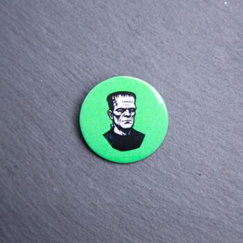 Frankenstein Button. These buttons are made with photo paper, metal round, and metal backing. These buttons are vibrant and fun to use on bags or vests.