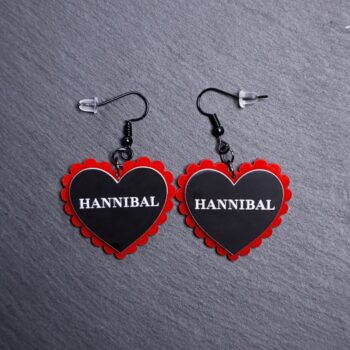 Hannibal Pillow Earrings that are white, black and red. These earrings are made with engraved acrylic. Comes with black hooks that is nickel free.