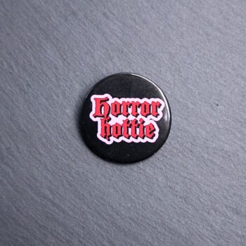 Horror Hottie Button. These buttons are made with photo paper, metal round, and metal backing. These buttons are vibrant and fun to use on bags or vests.