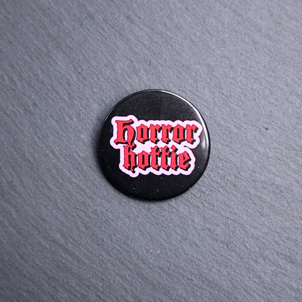 Horror Hottie Button. These buttons are made with photo paper, metal round, and metal backing. These buttons are vibrant and fun to use on bags or vests.
