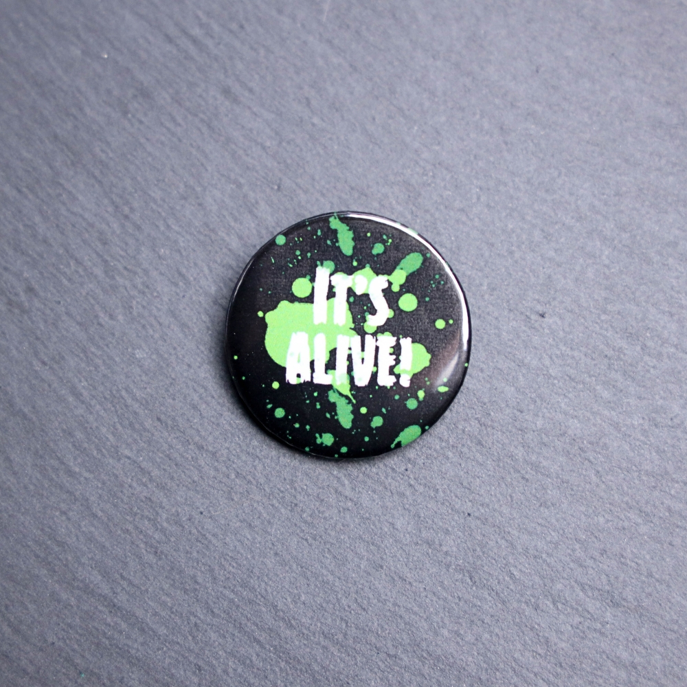 It's Alive Button. These buttons are made with photo paper, metal round, and metal backing. These buttons are vibrant and fun to use on bags or vests.
