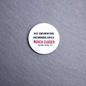 Jaws Beach Sign Button. These buttons are made with photo paper, metal round, and metal backing. These buttons are vibrant and fun to use on bags or vests.