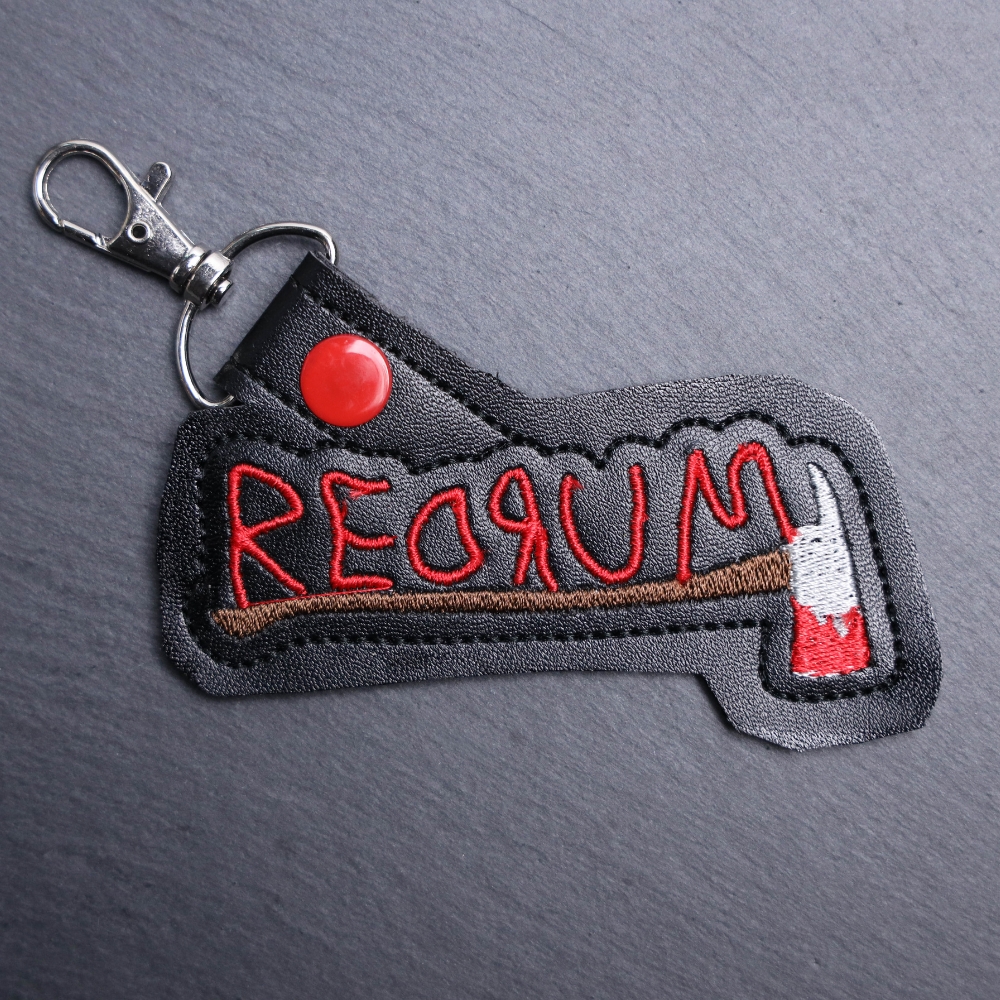 Redrum Snap Bag Tag. This bag tag is made with faux vinyl and embroidered. Comes with lobster clasp topper that easily hooks to a bag, zippers