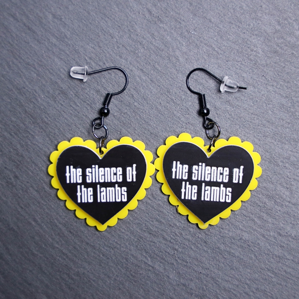 Silence Of The Lambs Pillow Earrings that are white, black and yellow. These earrings are made with engraved acrylic. Comes with black hooks that is nickel free.