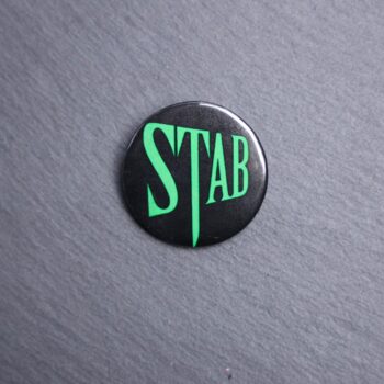 Stab Button. These buttons are made with photo paper, metal round, and metal backing. These buttons are vibrant and fun to use on bags or vests.