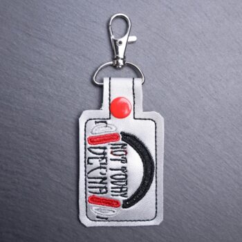 Vecna Snap Bag Tag. This bag tag is made with faux vinyl and embroidered. Comes with lobster clasp topper that easily hooks to a bag, zippers
