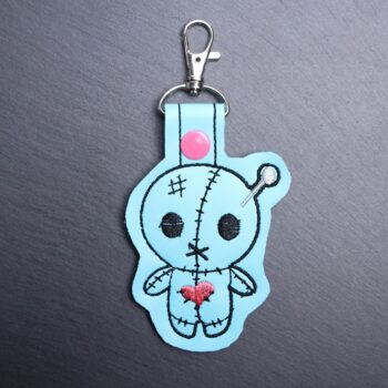 Voodoo Snap Bag Tag. This bag tag is made with faux vinyl and embroidered. Comes with lobster clasp topper that easily hooks to a bag, zippers