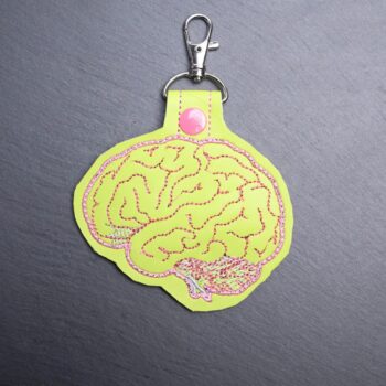 Zombie Brain Snap Bag Tag. This bag tag is made with faux vinyl and embroidered. Comes with lobster clasp topper that easily hooks to a bag, zippers