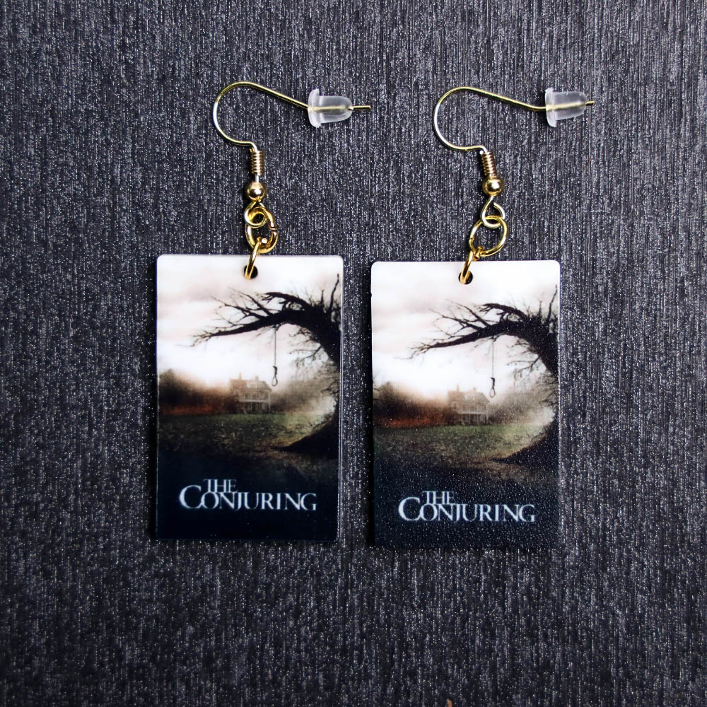The Conjuring Poster Earrings. These earrings are made with acrylic and hand heat pressed. Comes with 18k plated gold hooks that is nickel free.