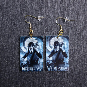 Wednesday Addams Poster Earrings. These earrings are made with acrylic and hand heat pressed. Comes with 18k plated gold hooks that is nickel free.